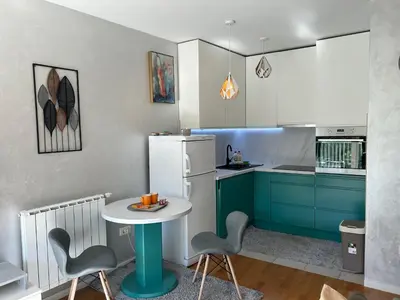 a kitchen with blue cabinets and a table and chairs at CENTRAL POINT APARTMENT - City centar Zenica- in Zenica