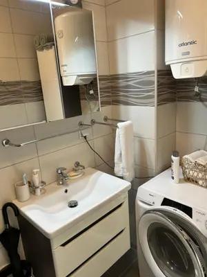 a bathroom with a sink and a washing machine at CENTRAL POINT APARTMENT - City centar Zenica- in Zenica