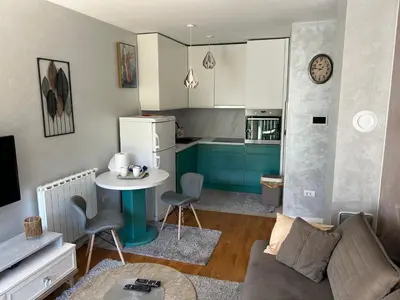 a living room with a couch and a table and a kitchen at CENTRAL POINT APARTMENT - City centar Zenica- in Zenica
