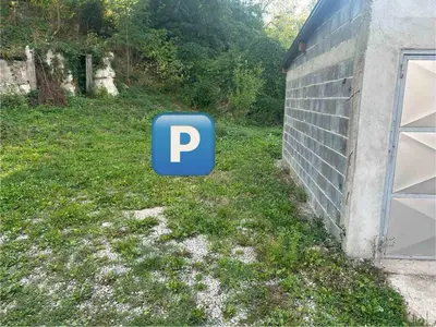 a blue parking sign in the grass next to a building at CENTRAL POINT APARTMENT - City centar Zenica- in Zenica