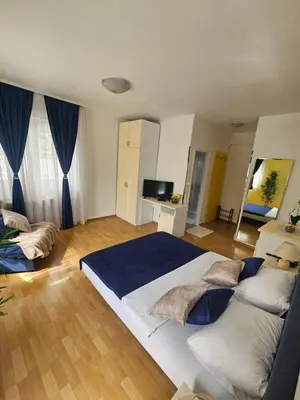 a bedroom with a large white bed with blue sheets at Rooms MIG in Banja Luka