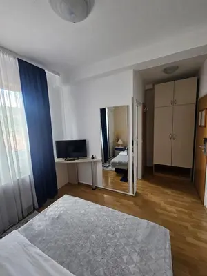 a bedroom with a large bed and a mirror at Rooms MIG in Banja Luka