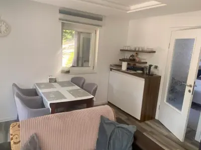 a living room with a table and a kitchen at Vila Beganovic in Šišava