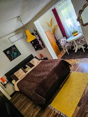 a bedroom with a large bed with a brown blanket at Apartmani S Banja Luka in Pištelići