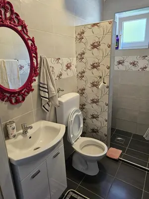 a bathroom with a toilet and a sink and a mirror at Apartmani S Banja Luka in Pištelići