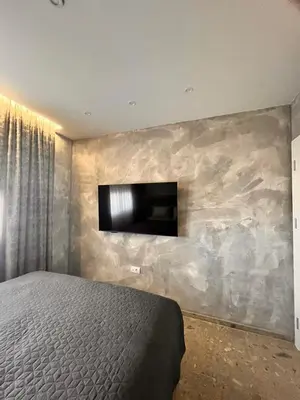 a bedroom with a bed and a tv on a wall at Relax Apartman DMBL in Banja Luka