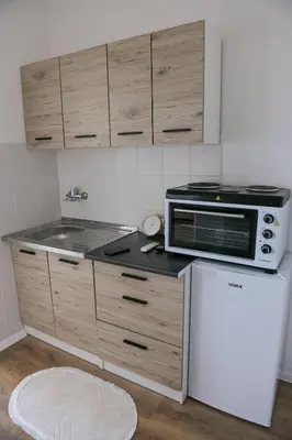a small kitchen with a microwave and a refrigerator at Stan na dan-Studio 10 centar Gradiška in Bosanska Gradiška