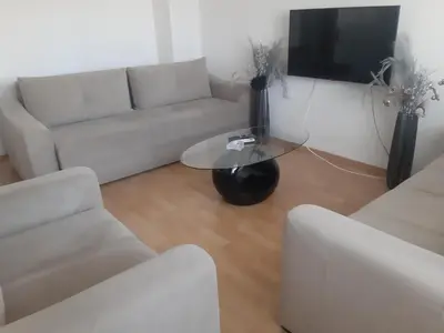 a living room with a white couch and a table at CenterZeroZoneOne in Banja Luka
