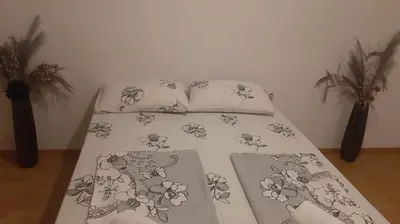 a bed with a comforter and two pillows at CenterZeroZoneOne in Banja Luka