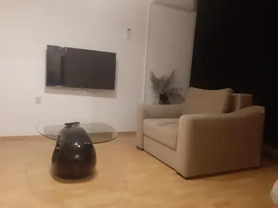 a living room with a couch and a table and a tv at CenterZeroZoneOne in Banja Luka