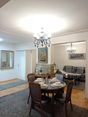 a dining room and living room with a table and chairs at Apartman Centar in Banja Luka
