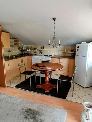 a kitchen with a table and a refrigerator at CentarTuzla in Tuzla