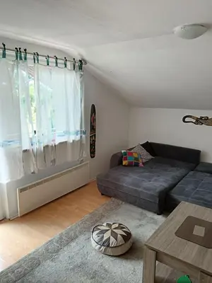 a living room with a bed and a table at CentarTuzla in Tuzla