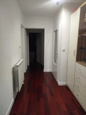 a hallway of an apartment with white walls and wood floors at Apartman Travnik in Travnik
