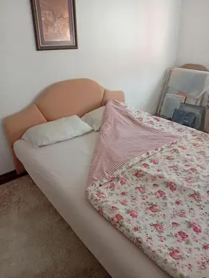 a bed with a flowered blanket on top of it at Apartman Travnik in Travnik