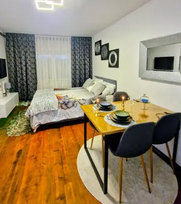 a bedroom with a bed and a table and a dining room at Old Town Maglaj 2, Center ,Parking in Maglaj
