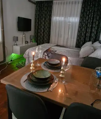 a table with plates and wine glasses on top of it at Old Town Maglaj 2, Center ,Parking in Maglaj