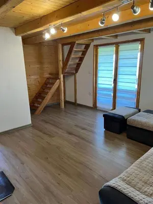 a large room with wooden floors and wooden stairs at Vikendica Neprivaj in Vareš