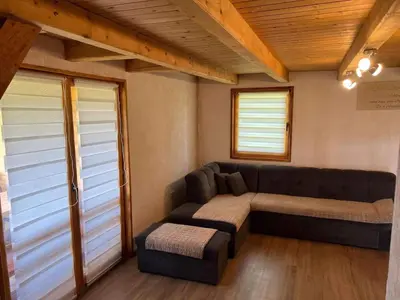 a living room with a couch and a ottoman at Vikendica Neprivaj in Vareš