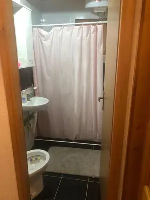 a bathroom with a white shower curtain and a toilet at Vikendica Neprivaj in Vareš