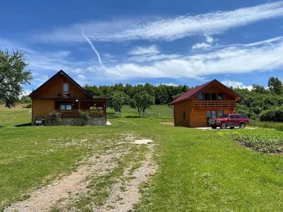 a house and a truck parked in a field at Vikendica Neprivaj in Vareš