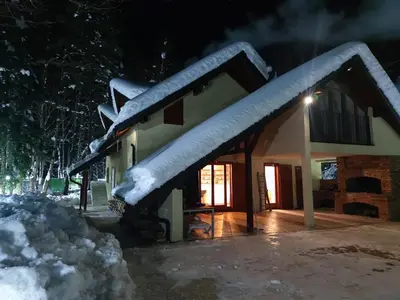 a house with snow on the roof at night at Villa Kamenica in Zavidovići