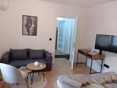 a living room with a couch and a tv at Apartman Leky in Tuzla
