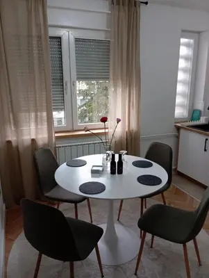 a white table and chairs in a room at Apartman Leky in Tuzla