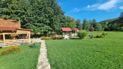a garden with a building and a grass field at Simetić