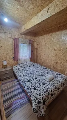 a bedroom with a large bed in a stone wall at Simetić