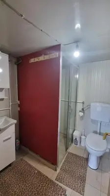 a bathroom with a red door and a toilet at Simetić