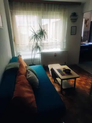 a living room with a blue couch and a table at Sunny Banja Luka in Banja Luka