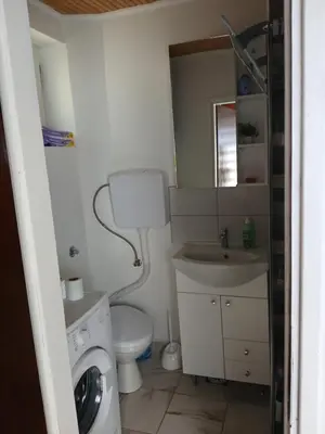 a bathroom with a washing machine and a sink at Studio apartman MA Kostajnica in Kostajnica