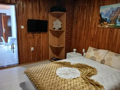 a bedroom with a bed with a blanket on it at Studio apartman MA Kostajnica in Kostajnica