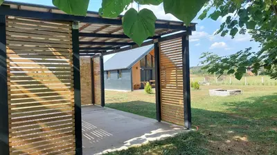 a wooden pergola on the side of a house at Kovačnica 55