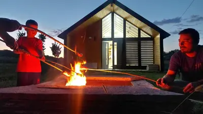a couple of people are around a fire at Kovačnica 55