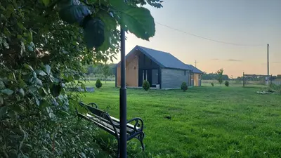 a park bench in a field with a building at Kovačnica 55