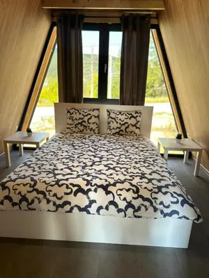 a large bed in a room with a large window at A Frame house Slavuljica in Vlasic