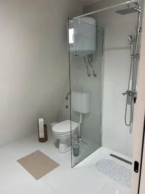 a bathroom with a toilet and a glass shower at A Frame house Slavuljica in Vlasic