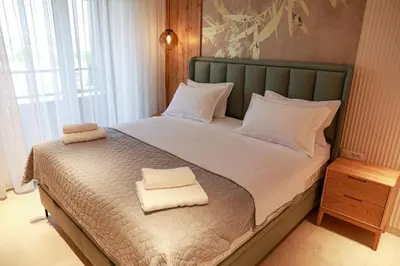 a bedroom with a bed with two towels on it at Luxury Palata Penthouse Apartments in Banja Luka