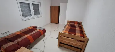 a bedroom with two beds and a window at Apartment Sikira in Visoko