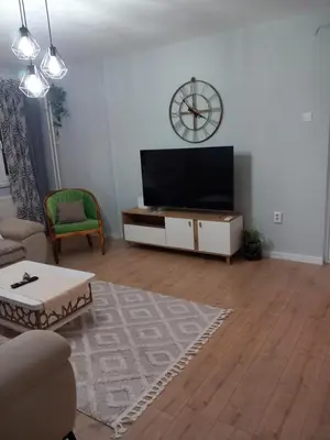 a living room with a flat screen tv on a cabinet at Apartman AM Tuzla in Tuzla