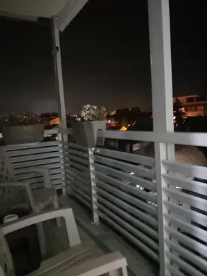 a balcony with a view of the city at night at Apartman AM Tuzla in Tuzla
