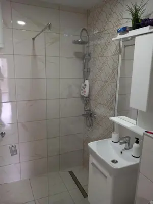 a bathroom with a shower and a toilet and a sink at Apartman AM Tuzla in Tuzla