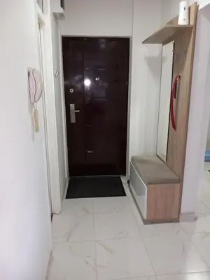a bathroom with a black door and a tile floor at Apartman AM Tuzla in Tuzla