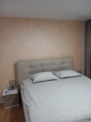 a bedroom with a large bed with white sheets and pillows at SlatinaApartman in Tuzla
