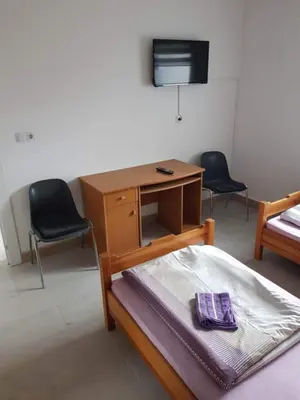 a room with a desk and two chairs and a tv at Sobe Kod Ćobe in Matuzići