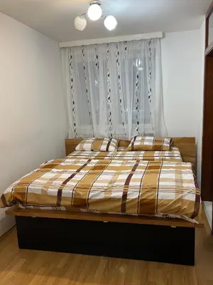 a bed with a striped comforter in a bedroom at Tajni kutak in Bosanska Gradiška