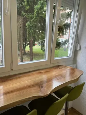 a wooden bench in front of a window at Tajni kutak in Bosanska Gradiška