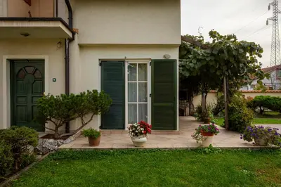 a house with green doors and flowers in the yard at Villa Garden in Banja Luka
